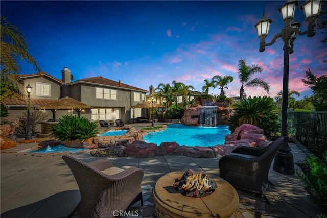 pool featuring an outdoor fire pit, fence, and a patio