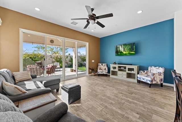 living room featuring light wood-style floors, recessed lighting, visible vents, and baseboards