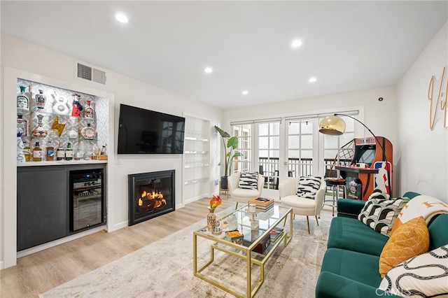 living room with light wood-type flooring, visible vents, recessed lighting, and wine cooler