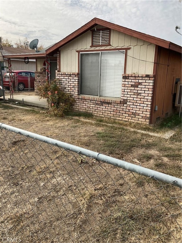 view of property exterior with fence and brick siding