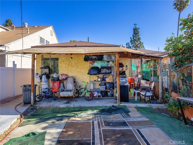 rear view of property featuring fence and stucco siding