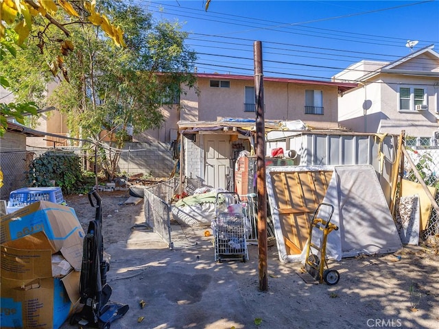 rear view of house with fence and stucco siding