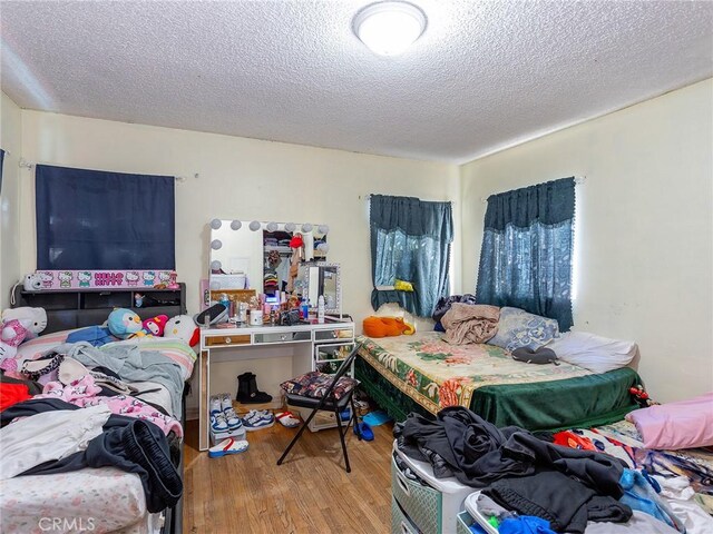 bedroom featuring a textured ceiling and wood finished floors