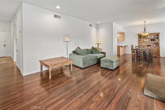 living area featuring baseboards, visible vents, wood finished floors, and recessed lighting