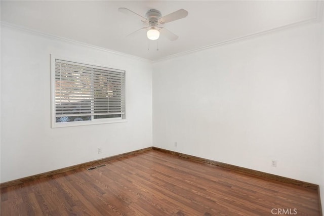 empty room featuring ceiling fan, wood finished floors, visible vents, baseboards, and ornamental molding