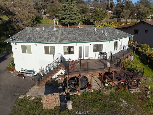 back of house featuring roof with shingles, stairway, and a wooden deck