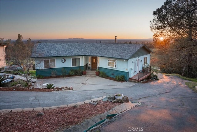 view of front facade featuring driveway and roof with shingles