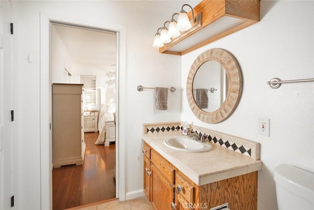 bathroom with vanity, toilet, and wood finished floors