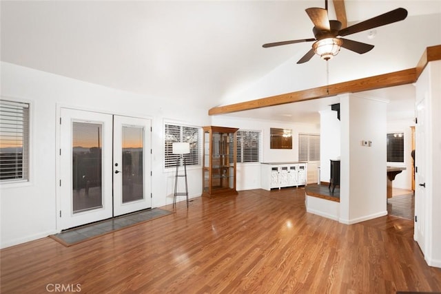 unfurnished living room featuring baseboards, a ceiling fan, wood finished floors, vaulted ceiling, and french doors