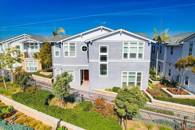 view of front of property featuring a fenced backyard, a residential view, and a patio