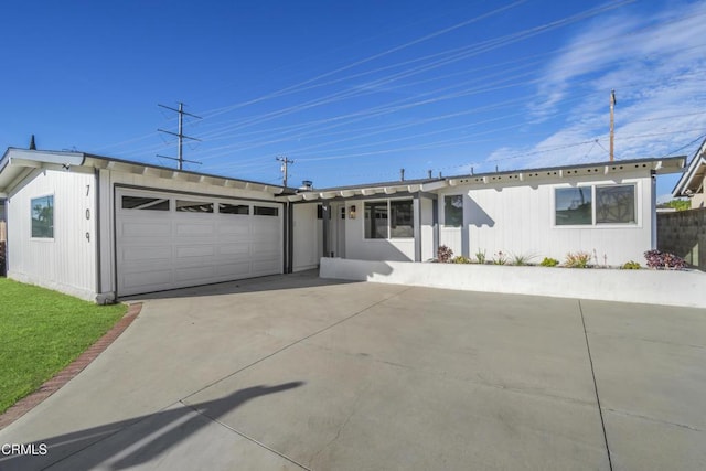 ranch-style home featuring a garage and concrete driveway