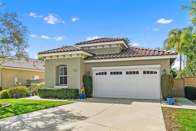 mediterranean / spanish-style house featuring driveway, an attached garage, and stucco siding