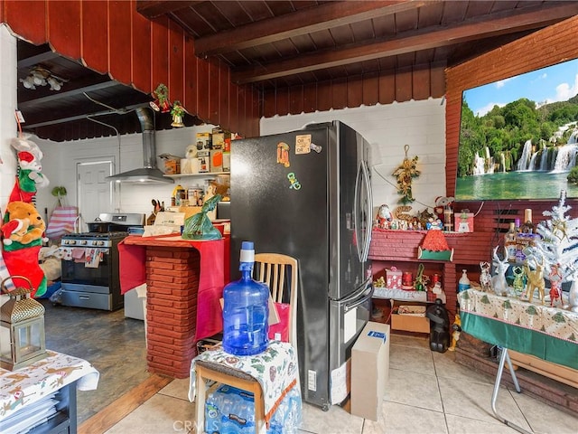 kitchen with light tile patterned floors, wooden ceiling, appliances with stainless steel finishes, beam ceiling, and wall chimney exhaust hood