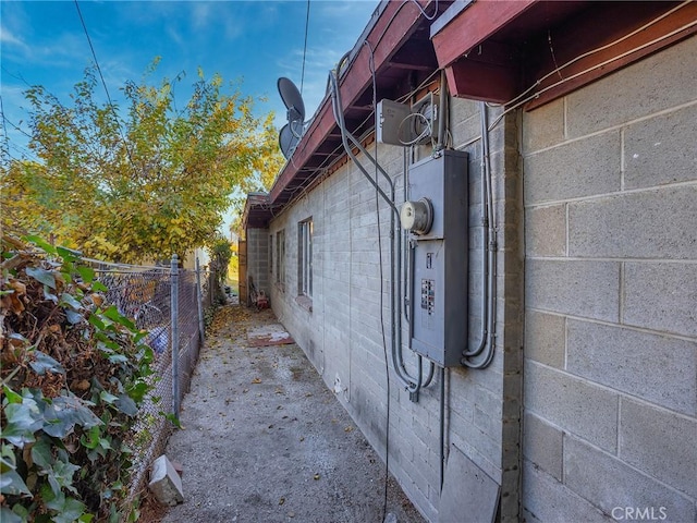 view of property exterior with concrete block siding and fence