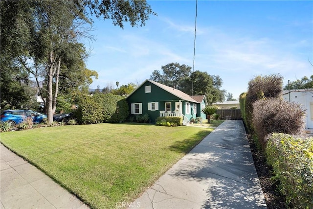 view of side of home with fence, a lawn, and concrete driveway