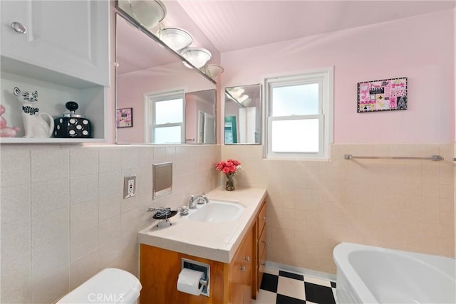 bathroom featuring tile patterned floors, vanity, tile walls, and a healthy amount of sunlight