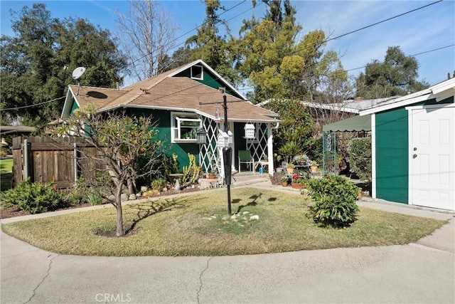 bungalow featuring a front yard and an outdoor structure