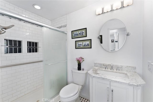 full bathroom featuring a stall shower, vanity, and toilet