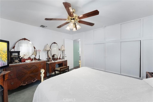 carpeted bedroom featuring visible vents and a ceiling fan