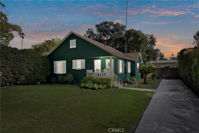 bungalow-style house with a yard and fence