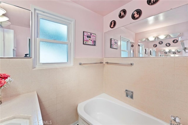 bathroom with a bathing tub and tile walls