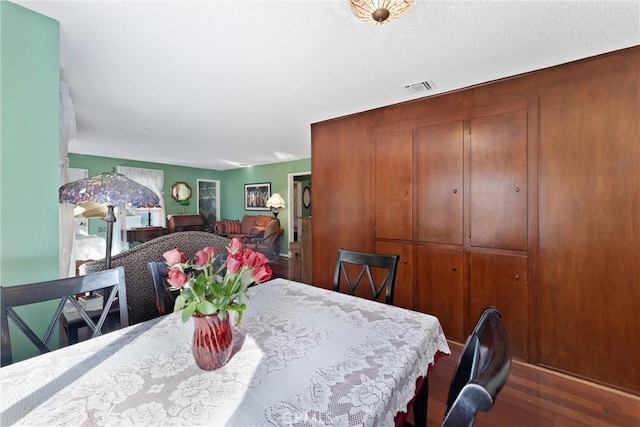 dining space with wood finished floors and visible vents