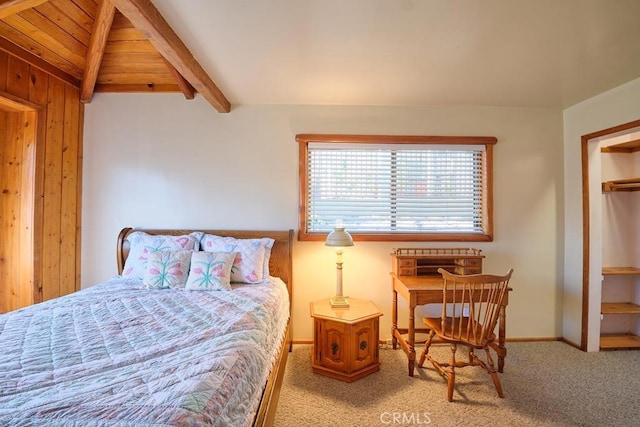 carpeted bedroom with baseboards and beam ceiling