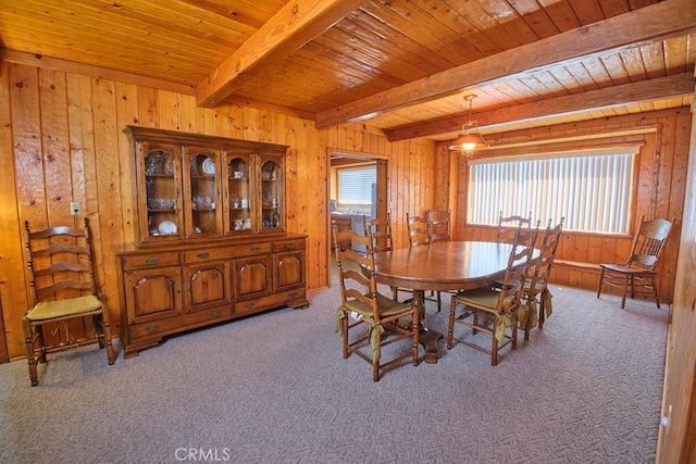 carpeted dining space featuring wooden walls, wood ceiling, and beam ceiling