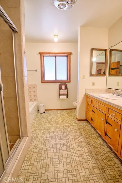 bathroom featuring vanity, brick patterned floor, a shower stall, and toilet