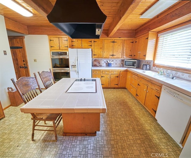 kitchen with wooden ceiling, appliances with stainless steel finishes, tile countertops, and island exhaust hood