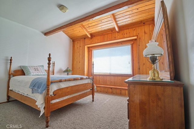 carpeted bedroom with wooden walls, wood ceiling, and vaulted ceiling with beams