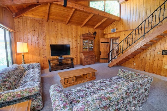 carpeted living room featuring visible vents, a healthy amount of sunlight, wooden walls, and wooden ceiling