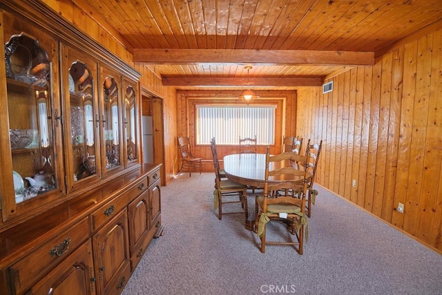 dining area with wood walls, wooden ceiling, beam ceiling, and carpet