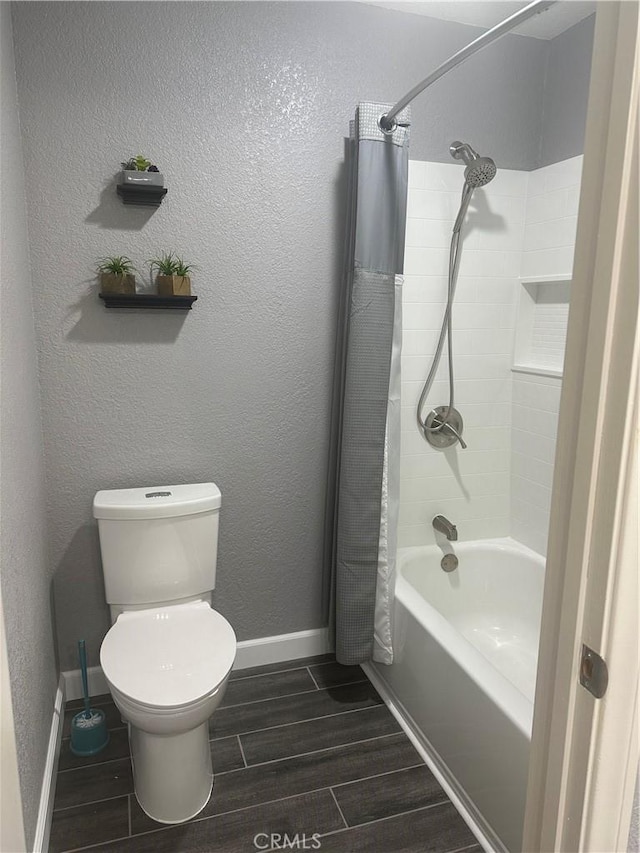 full bath featuring a textured wall, toilet, wood finish floors, baseboards, and shower / bath combination with curtain