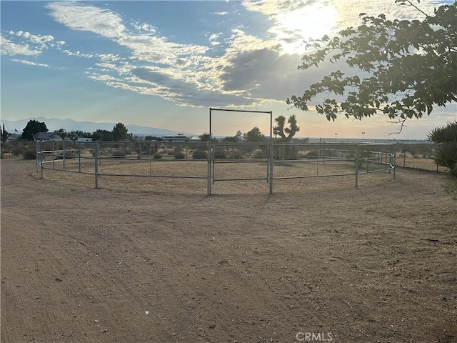 view of yard featuring a rural view, a mountain view, and fence