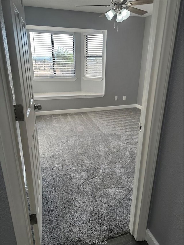 unfurnished room featuring carpet floors, baseboards, and a ceiling fan