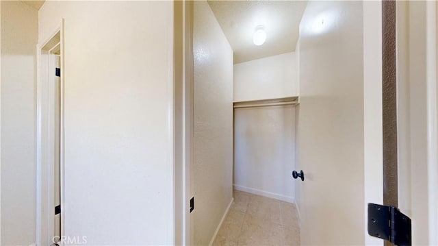 laundry area with baseboards and light tile patterned floors