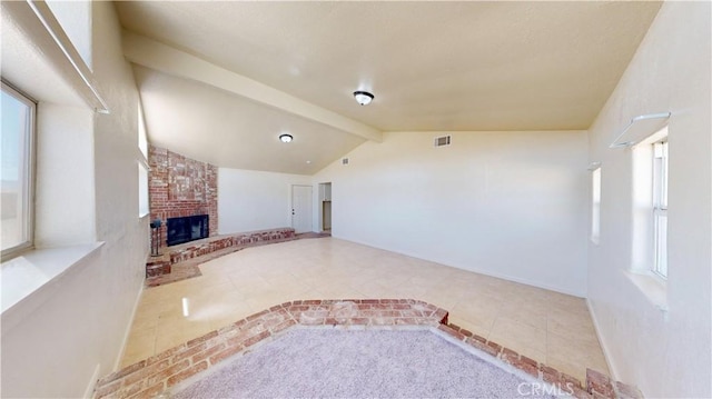 unfurnished living room with lofted ceiling with beams, a fireplace, visible vents, and tile patterned floors