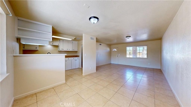 interior space featuring visible vents, baseboards, and light tile patterned flooring