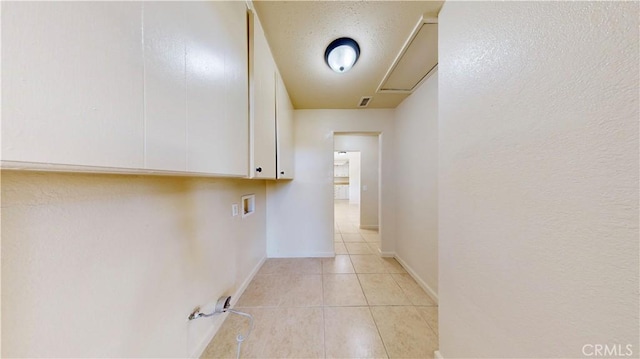 hallway with visible vents, a textured ceiling, and light tile patterned flooring