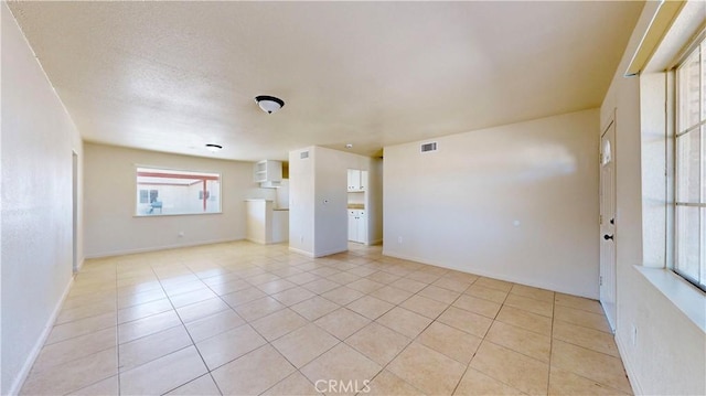 unfurnished room featuring light tile patterned floors, visible vents, and baseboards