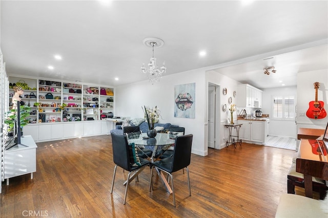 dining area featuring dark wood-type flooring, recessed lighting, and a notable chandelier