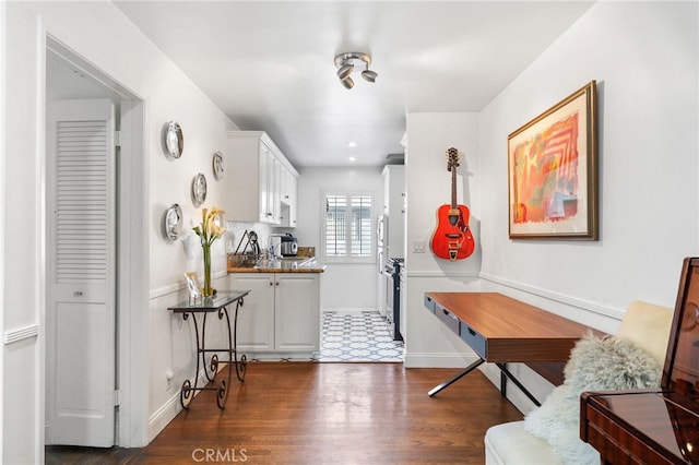 kitchen with dark wood-style floors, baseboards, white cabinetry, and light countertops