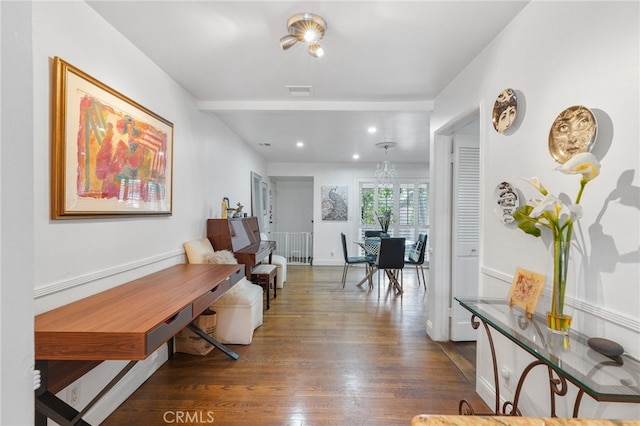 corridor featuring dark wood-type flooring, recessed lighting, visible vents, and baseboards