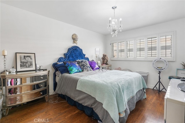 bedroom featuring dark wood-type flooring, baseboards, and an inviting chandelier