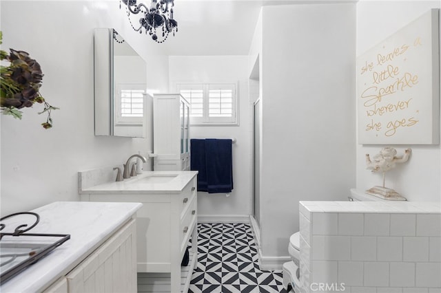 bathroom featuring a stall shower, vanity, toilet, and baseboards