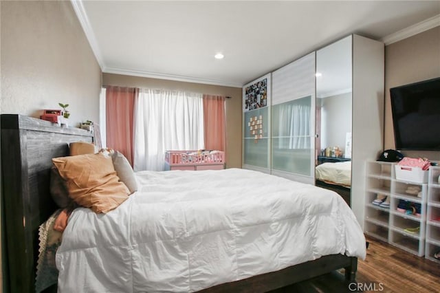 bedroom featuring ornamental molding and wood finished floors