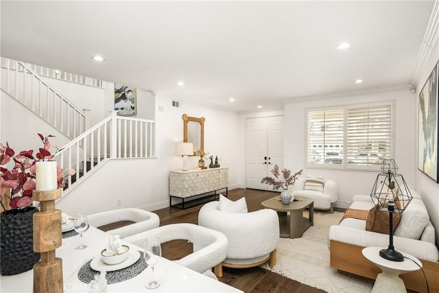 living area with visible vents, crown molding, stairway, and wood finished floors