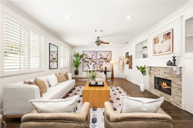 living area featuring wood finished floors, visible vents, built in features, a ceiling fan, and ornamental molding