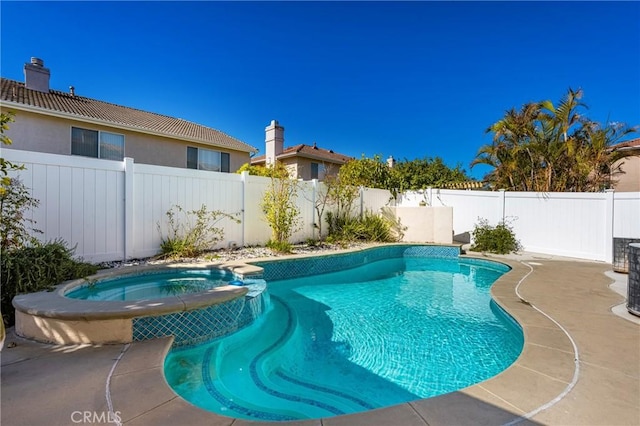 view of pool featuring a fenced backyard, a pool with connected hot tub, and a patio